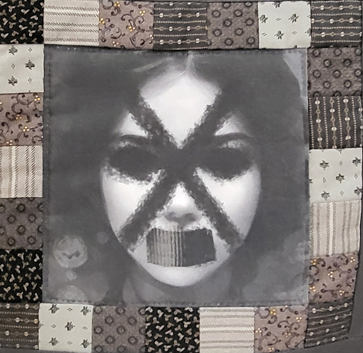 Detail from The Matrix of Discomfort showing an AI-generated grayscale face with an X over the eyes and tape-like mark over the mouth, bordered by quilt blocks.